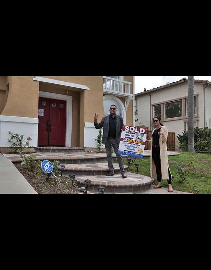 Sharad Gupta, with a victorious peace sign, stands next to a pleased client in front of a house marked 'SOLD' by Your Home Sold Guaranteed Realty.