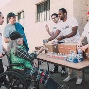 A lady on wheelchair being helped by a non-profit